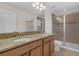 Bathroom featuring double sinks, granite countertops, and a glass-enclosed shower at 15483 Avenue Of The Arbors, Winter Garden, FL 34787