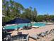 Relaxing community pool area with comfortable lounge chairs and umbrellas for shade at 15483 Avenue Of The Arbors, Winter Garden, FL 34787