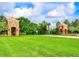 Community entrance with decorative brick towers, manicured lawn and lush landscaping at 15483 Avenue Of The Arbors, Winter Garden, FL 34787