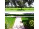 Manicured front yard with a walkway leading to the green lawn and large trees at 15483 Avenue Of The Arbors, Winter Garden, FL 34787