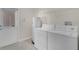 Bright laundry room featuring a washer, dryer, and water heater near the exterior door at 15483 Avenue Of The Arbors, Winter Garden, FL 34787