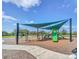 Community playground with shade structure, swings, slide and mulch ground cover at 15483 Avenue Of The Arbors, Winter Garden, FL 34787