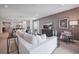 Open-concept living room featuring a plush sofa, light wood floors, and integrated kitchen and dining area at 1802 Lattice Way, St Cloud, FL 34771