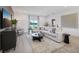 Well-lit living room with light wood floors, a sectional sofa, and view of the backyard at 1802 Lattice Way, St Cloud, FL 34771