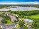 Aerial community view showcasing pool, surrounding trees and community buildings with a beautiful lake in the distance at 2005 Compass Flower Way, Ocoee, FL 34761