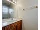 Bright bathroom with wood vanity, sleek white countertop, and a large mirror at 2005 Compass Flower Way, Ocoee, FL 34761
