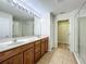 Bright bathroom featuring a double sink vanity, large mirror with vanity lighting and glass enclosed shower at 2005 Compass Flower Way, Ocoee, FL 34761