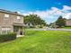 Exterior view of a well-maintained townhome with a green lawn and nearby street, offering a sense of community at 2005 Compass Flower Way, Ocoee, FL 34761