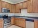 Charming kitchen featuring wood cabinetry, stainless steel appliances and neutral countertops at 2005 Compass Flower Way, Ocoee, FL 34761