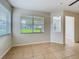 Inviting living room with large windows, letting in natural light, and neutral tile flooring at 2005 Compass Flower Way, Ocoee, FL 34761