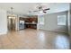 Open living room featuring tile floors, a ceiling fan, and an adjacent kitchen with stainless steel appliances at 2005 Compass Flower Way, Ocoee, FL 34761
