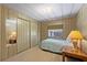 Cozy bedroom featuring wood paneled walls, a small window, and a comfortably sized bed at 2060 Lamplight Cir, Mount Dora, FL 32757