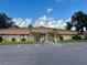 Community clubhouse with ample parking, covered entrance, and attractive landscaping at 2060 Lamplight Cir, Mount Dora, FL 32757