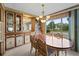 Formal dining room with a large wood table, ornate chandelier, and display cabinet at 2060 Lamplight Cir, Mount Dora, FL 32757