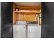Bright laundry area with washer, dryer, shelves, and black louvered doors at 2060 Lamplight Cir, Mount Dora, FL 32757