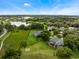 An aerial view shows a house with lake views, sprawling green space, and mature landscaping at 2106 Ridgewind Way, Windermere, FL 34786