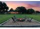 Relaxing backyard featuring a fire pit with seating, surrounded by a spacious lawn and mature trees at 2106 Ridgewind Way, Windermere, FL 34786