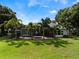 The backyard has a spacious lawn, mature palms, and an enclosed pool area with covered seating at 2106 Ridgewind Way, Windermere, FL 34786