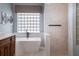 Elegant bathroom with a soaking tub, walk-in shower, and glass block window at 2106 Ridgewind Way, Windermere, FL 34786