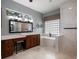 Bathroom featuring dual vanities, a soaking tub, walk-in shower, and glass block window at 2106 Ridgewind Way, Windermere, FL 34786