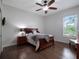 Cozy bedroom featuring wood floors, a ceiling fan, and a view of the yard at 2106 Ridgewind Way, Windermere, FL 34786