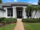 Elegant home with a stately entrance, featuring columns, mature landscaping, and a well-manicured lawn at 2106 Ridgewind Way, Windermere, FL 34786