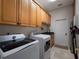 Functional laundry room with overhead cabinets, wash sink, and modern appliances at 2106 Ridgewind Way, Windermere, FL 34786