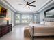 Comfortable main bedroom featuring tray ceilings, a ceiling fan, and private backyard views at 2106 Ridgewind Way, Windermere, FL 34786