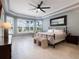 Bright main bedroom featuring tray ceilings, a ceiling fan, and large windows at 2106 Ridgewind Way, Windermere, FL 34786