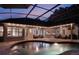 Covered lanai with ample seating and a beautiful pool at twilight at 2106 Ridgewind Way, Windermere, FL 34786