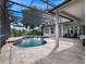 Screened in patio featuring a uniquely shaped pool, tiled flooring, outdoor seating, and mature landscaping at 2106 Ridgewind Way, Windermere, FL 34786