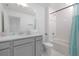Bright bathroom with white tiled shower, tub and modern gray vanity with a large mirror at 2363 Lancashire St, Davenport, FL 33896