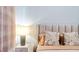 A lamp sits on a nightstand beside a bed with accent pillows and a padded headboard at 2363 Lancashire St, Davenport, FL 33896