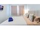Modern bedroom features clean white bedding, contemporary bedside table, and window with privacy blinds at 2363 Lancashire St, Davenport, FL 33896