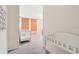 Light-filled bedroom featuring a crib with colorful accents and a changing table at 2363 Lancashire St, Davenport, FL 33896