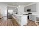 Bright kitchen features gray cabinets, stainless steel appliances, island with bar seating at 2363 Lancashire St, Davenport, FL 33896