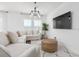 Bright living room featuring a sectional sofa, area rug, and a mounted television at 2363 Lancashire St, Davenport, FL 33896