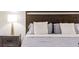 Stylish bed with decorative pillows and a nightstand featuring a sleek lamp at 2363 Lancashire St, Davenport, FL 33896