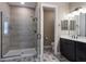 Modern bathroom features a glass-enclosed shower, sleek vanity, and stylish patterned tile flooring at 245 Bella Verano Way, Davenport, FL 33897