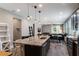 Modern open-concept kitchen with a granite island, stainless steel appliances, and an adjacent dining area at 245 Bella Verano Way, Davenport, FL 33897