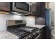 Close-up of modern kitchen details, including stainless steel appliances, granite countertops, and a stylish tile backsplash at 245 Bella Verano Way, Davenport, FL 33897