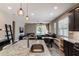 Modern open-concept kitchen with a granite island, stainless steel appliances, and an adjacent dining area at 245 Bella Verano Way, Davenport, FL 33897