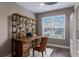 Cozy home office features a rustic wood desk with built-in shelving, hardwood floors, and a bright window at 245 Bella Verano Way, Davenport, FL 33897