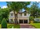 Charming two-story home features a manicured lawn, brick driveway, and inviting front porch with second-story balcony at 2607 Lafayette Ave, Winter Park, FL 32789