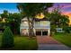 Charming two-story home features a manicured lawn, brick driveway, and inviting front porch with second-story balcony at 2607 Lafayette Ave, Winter Park, FL 32789