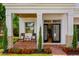 Inviting front porch with chairs, brick flooring, and meticulously maintained landscaping creates an appealing entrance at 2607 Lafayette Ave, Winter Park, FL 32789