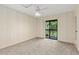 Bedroom featuring neutral carpet, ceiling fan, and sliding glass door to private balcony at 2636 Crown Ct, Kissimmee, FL 34741