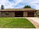 Charming single-story home featuring a stone facade, lush lawn, and attached garage at 2842 Blind Owl Dr, Orlando, FL 32822