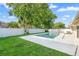 Clean backyard swimming pool with green grass, trees, and a white privacy fence, creating a relaxing atmosphere at 2871 Milstead St, Orlando, FL 32837