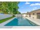 Backyard swimming pool surrounded by a concrete patio, green lawn, and a privacy fence, ideal for leisure and relaxation at 2871 Milstead St, Orlando, FL 32837